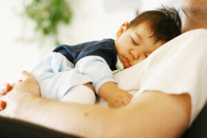 תינוק ישן על הבטן של אבא שלו